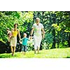 happy young couple with their children have fun at beautiful park outdoor in nature