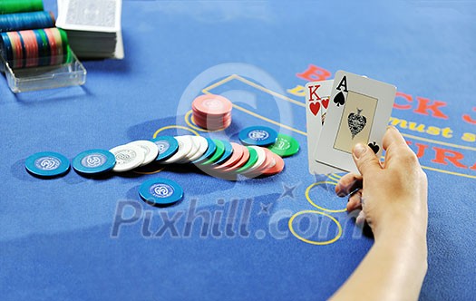 woman play black jack card game in casino on blue table woman play black jack card game in casino on blue table
