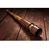 Vintage retro spyglass on wooden background