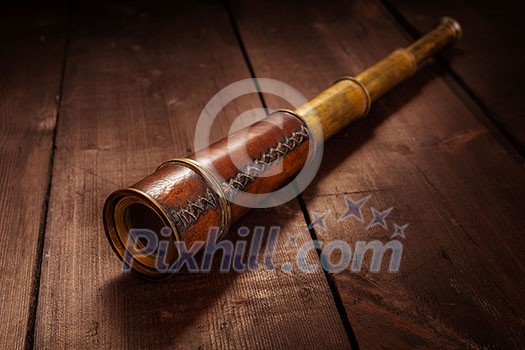 Vintage retro spyglass on wooden background Vintage retro spyglass on wooden background