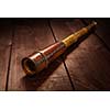 Vintage retro spyglass on wooden background