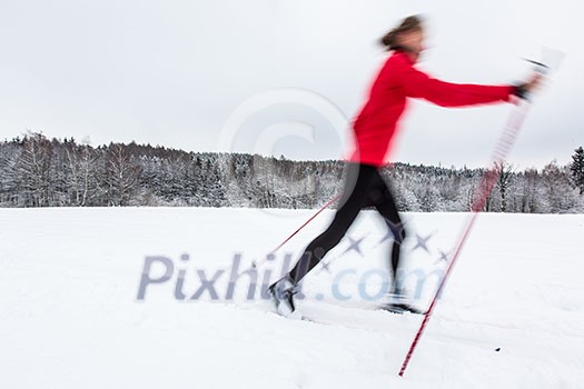 Cross-country skiing: young woman cross-country skiing on a winter day (motion blurred image) Cross-country skiing: young woman cross-country skiing on a winter day (motion blurred image)
