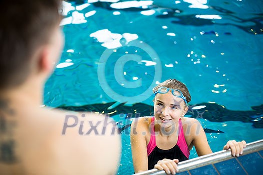 Female swimmer in an indoor swimming pool - doing crawl (shallow DOF) Female swimmer in an indoor swimming pool - doing crawl (shallow DOF)