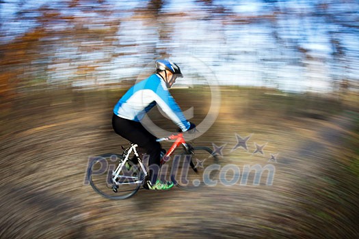 Bicycle riding in a city park on a lovely autumn/fall day (motion blur is used to convey movement) Bicycle riding in a city park on a lovely autumn/fall day (motion blur is used to convey movement)