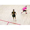 Two female squash players in fast action on a squash court (motion blurred image; color toned image)