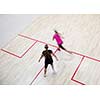 Two female squash players in fast action on a squash court (motion blurred image; color toned image)