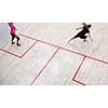 Two female squash players in fast action on a squash court (motion blurred image; color toned image)