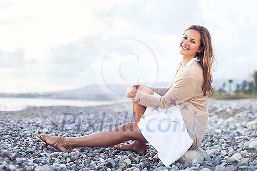 Young woman on the beach enjoying a warm summer evening Young woman on the beach enjoying a warm summer evening
