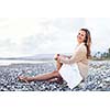 Young woman on the beach enjoying a warm summer evening