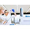 Two young researchers carrying out experiments in a lab (shallow DOF; color toned image)
