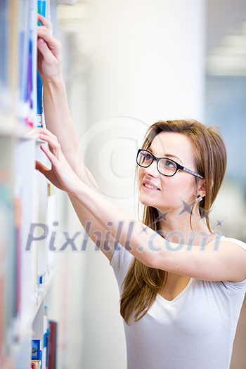 Pretty, female college student in a library, looking for a book (shallow DOF; color toned image) Pretty, female college student in a library, looking for a book (shallow DOF; color toned image)