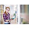 Pretty, female college student in a library, looking for a book (shallow DOF; color toned image)