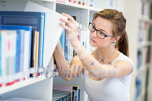 Pretty, female college student in a library, looking for a book (shallow DOF; color toned image) Pretty, female college student in a library, looking for a book (shallow DOF; color toned image)