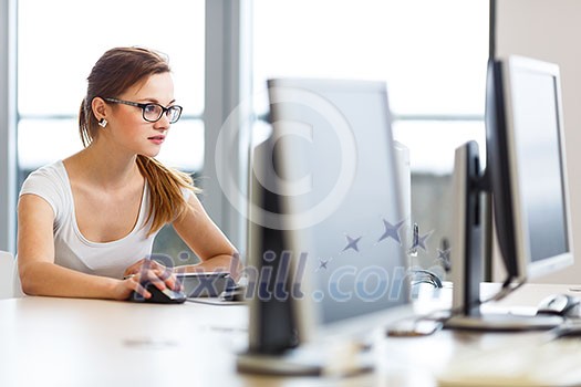 Pretty, female student looking at a desktop computer screen, learning unpleasant news about her exam results. University/office/school concept Pretty, female student looking at a desktop computer screen, learning unpleasant news about her exam results. University/office/school concept