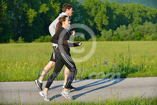 Young couple jogging in park at morning. Health and fitness. Young couple jogging in park at morning. Health and fitness.