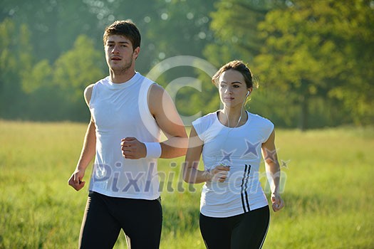 Young couple jogging in park at morning. Health and fitness concept Young couple jogging in park at morning. Health and fitness concept