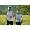 Young couple jogging in park at morning. Health and fitness concept
