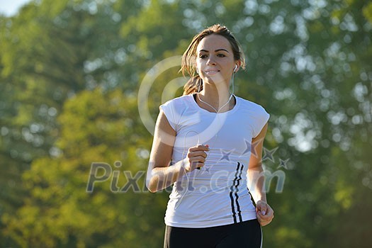 Young beautiful woman jogging on morning at park. Woman in sport outdoors health concept Young beautiful woman jogging on morning at park. Woman in sport outdoors health concept