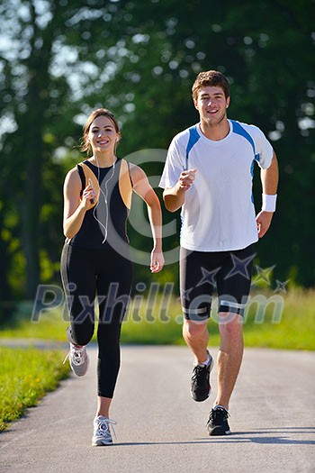 Young couple jogging in park at morning. Health and fitness. Young couple jogging in park at morning. Health and fitness.