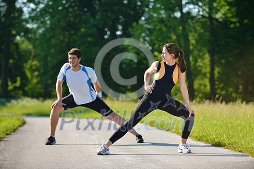 young health couple doing stretching exercise relaxing and warm up after jogging and running in park young health couple doing stretching exercise relaxing and warm up after jogging and running in park