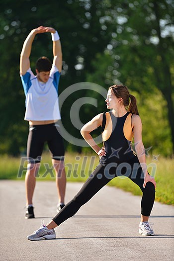young health couple doing stretching exercise relaxing and warm up after jogging and running in park young health couple doing stretching exercise relaxing and warm up after jogging and running in park