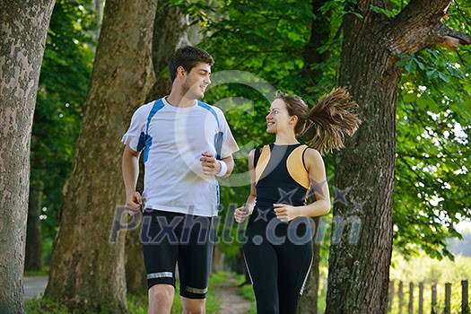 Young couple jogging in park at morning. Health and fitness concept Young couple jogging in park at morning. Health and fitness concept