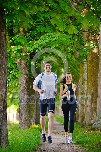 Young couple jogging in park at morning. Health and fitness. Young couple jogging in park at morning. Health and fitness.