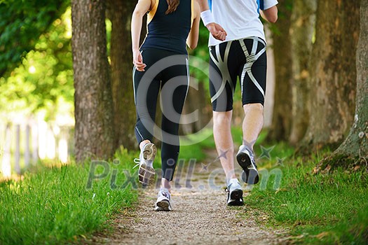 Young couple jogging in park at morning. Health and fitness concept Young couple jogging in park at morning. Health and fitness concept