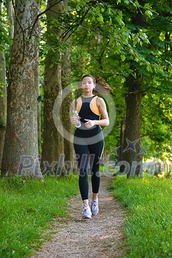 Young beautiful woman jogging in summer park. Woman in sport outdoors health concept Young beautiful woman jogging in summer park. Woman in sport outdoors health concept