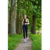 Young beautiful  woman jogging in summer park. Woman in sport outdoors health concept