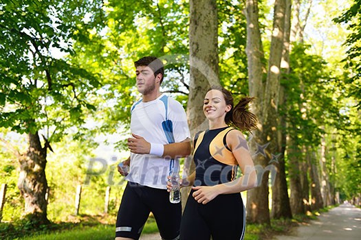 Young couple jogging in park at morning. Health and fitness. Young couple jogging in park at morning. Health and fitness.