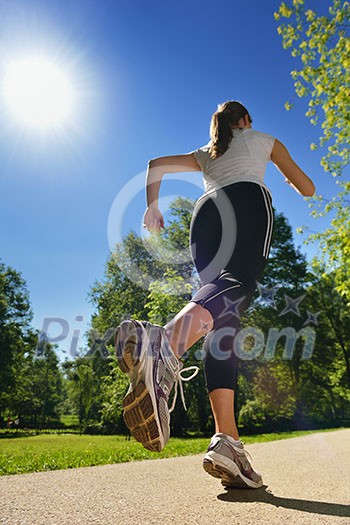 Young beautiful woman jogging on morning at park. Woman in sport outdoors health concept Young beautiful woman jogging on morning at park. Woman in sport outdoors health concept