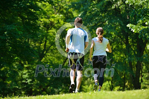 Young couple jogging in park at morning. Health and fitness. Young couple jogging in park at morning. Health and fitness.
