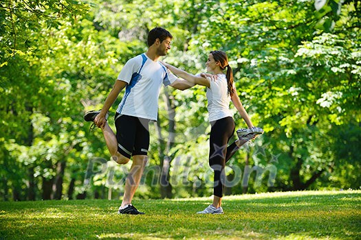 young health couple doing stretching exercise relaxing and warm up after jogging and running in park young health couple doing stretching exercise relaxing and warm up after jogging and running in park