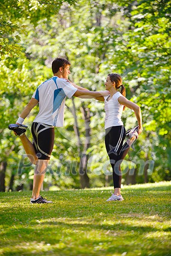 young health couple doing stretching exercise relaxing and warm up after jogging and running in park young health couple doing stretching exercise relaxing and warm up after jogging and running in park