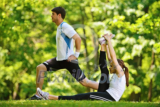 young health couple doing stretching exercise relaxing and warm up after jogging and running in park young health couple doing stretching exercise relaxing and warm up after jogging and running in park