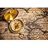 Old vintage retro golden compass on ancient map