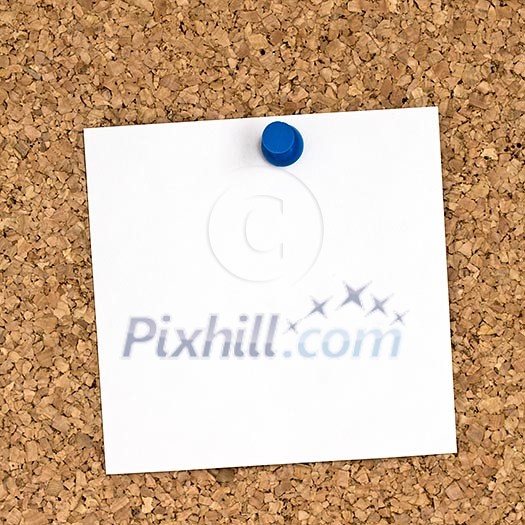 White note pinned to cork board close up White note pinned to cork board close up