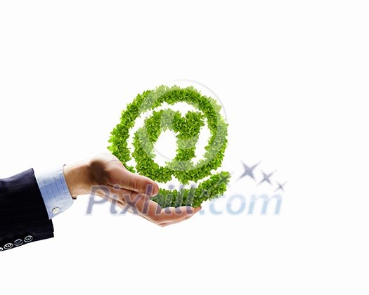 Image of human hand holding plant shaped like at symbol Image of human hand holding plant shaped like at symbol