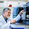 Senior male researcher carrying out scientific research in a lab (shallow DOF; color toned image)