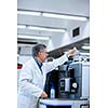 Senior male researcher carrying out scientific research in a lab (shallow DOF; color toned image)