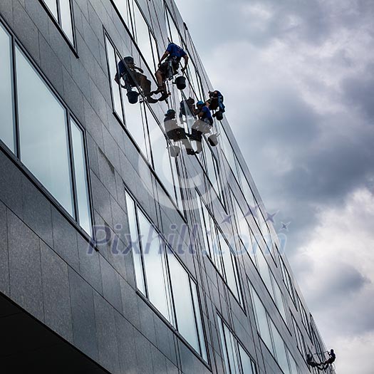 Climbers washing windows of a modern high-rise building Climbers washing windows of a modern high-rise building