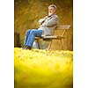 Senior man sitting on a bench in a park, enjoying retirement