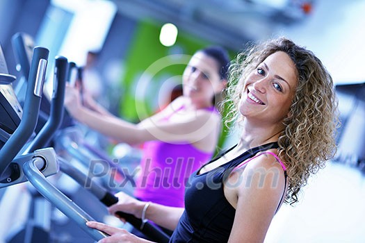 group of young people running on treadmills in modern sport gym group of young people running on treadmills in modern sport gym