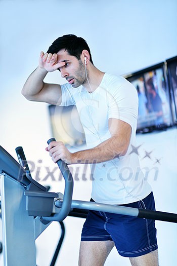 Handsome man running on the treadmill in modern gym Handsome man running on the treadmill in modern gym