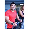 Handsome man running on the treadmill in modern gym