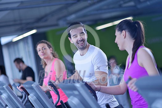 group of young people running on treadmills in modern sport gym group of young people running on treadmills in modern sport gym