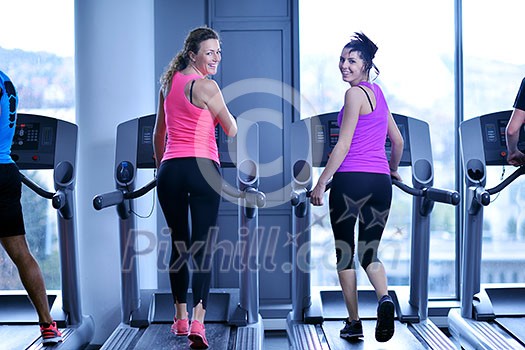 group of young people running on treadmills in modern sport gym group of young people running on treadmills in modern sport gym