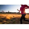 Young woman running outdoors on a lovely sunny winter/fall day (motion blurred image)