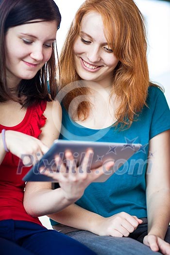 Young college students using a tablet computer in class (color toned image) Young college students using a tablet computer in class (color toned image)